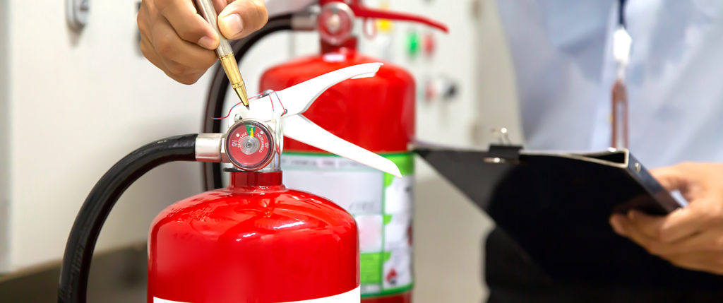 Man completing fire extinguisher inspection