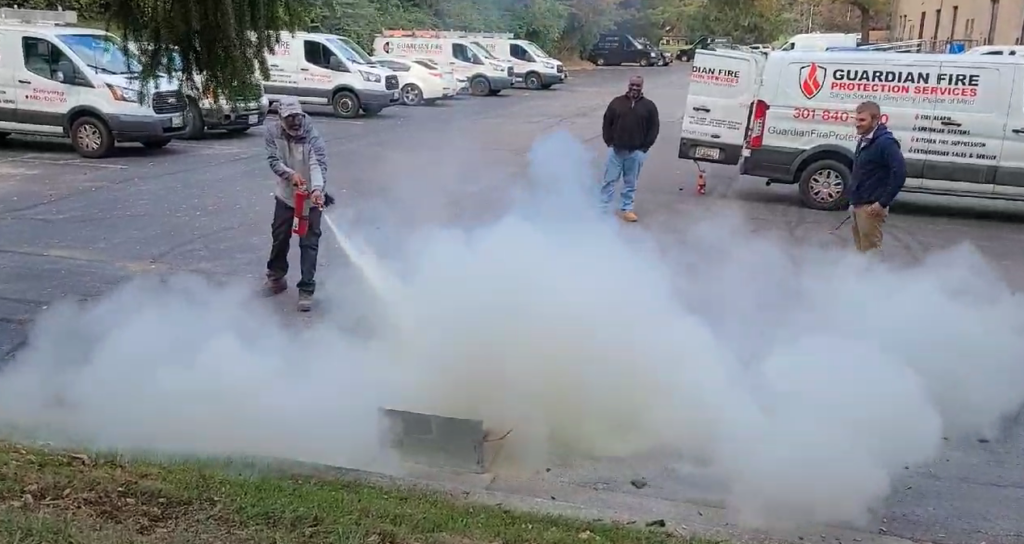 Members of Guardian Fire Protection practicing using fire extinguishers.