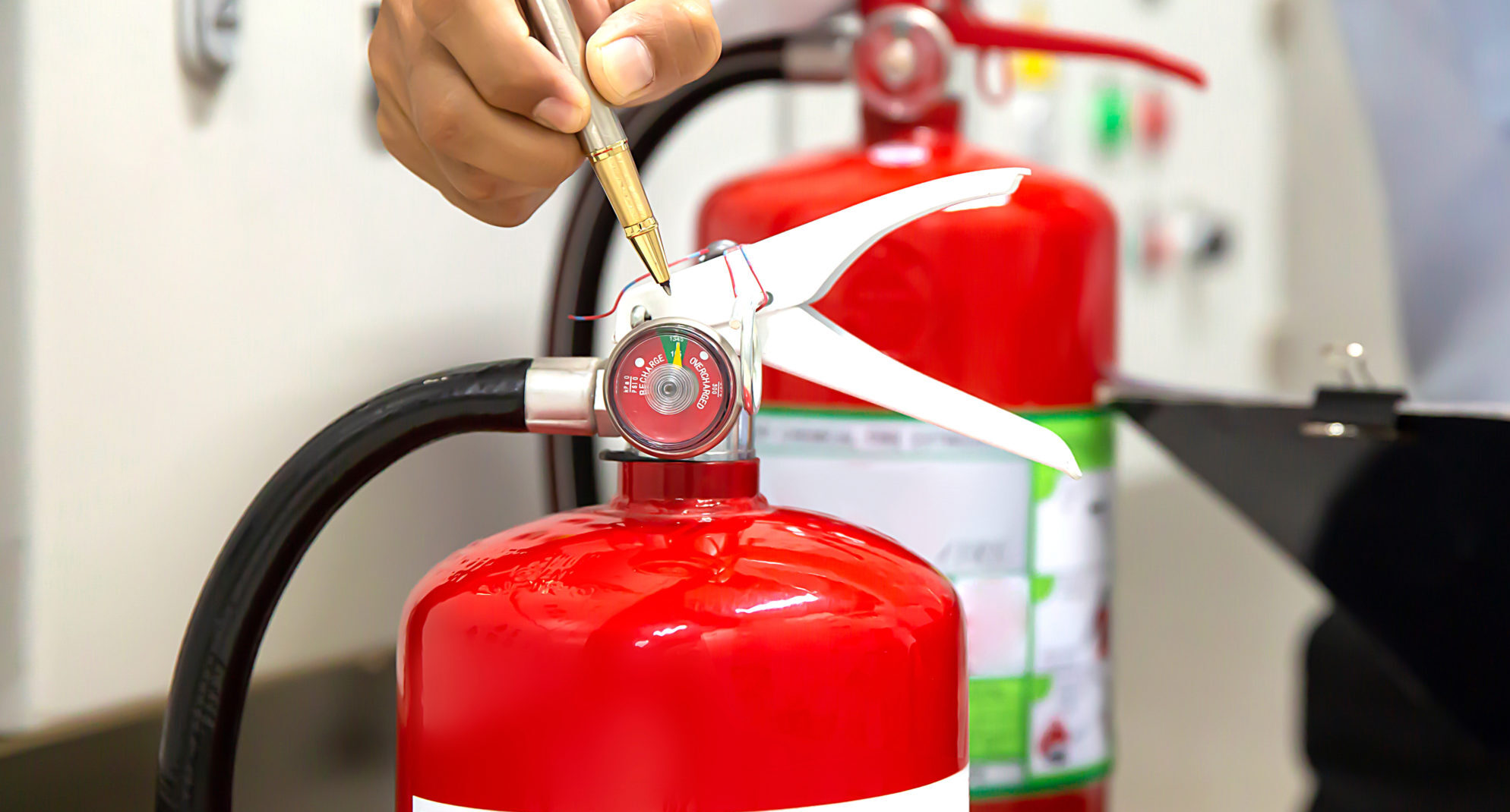 Man completing fire extinguisher inspection in prep for a fire marshal inspection